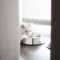 White cat eating from a stainless steel bowl
