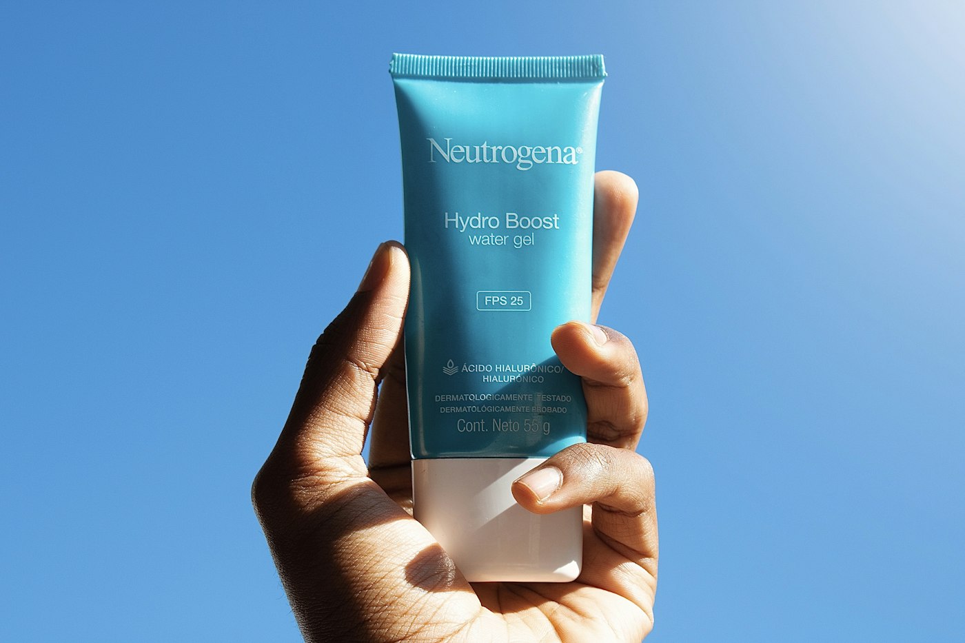 Hand holding a tube of daily sunscreen