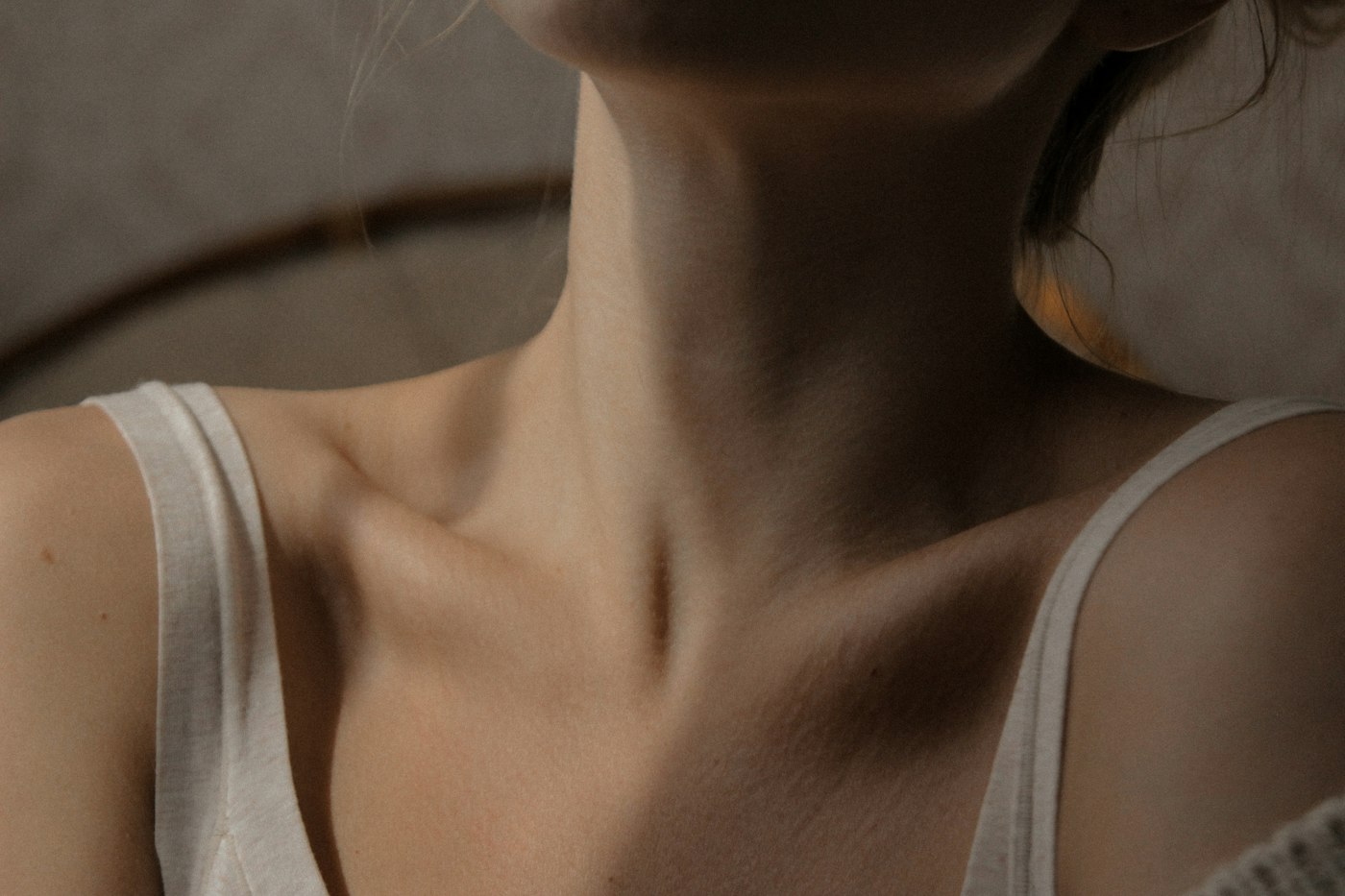 Woman in a white tank top showing smooth neck skin