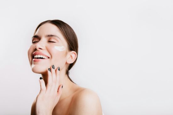 Smiling woman touching her face and neck as part of her skincare routine
