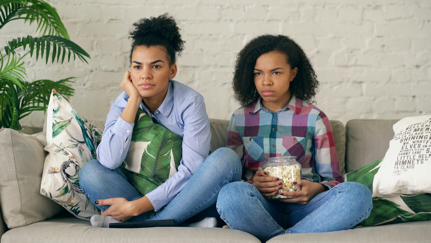 Friends watching a rom-com on the couch with popcorn
