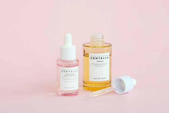 Skincare serums on a pink background