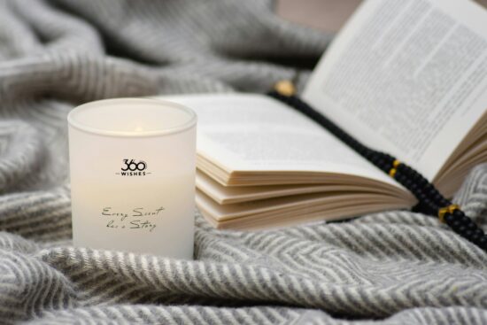 Candle and book on a cozy blanket
