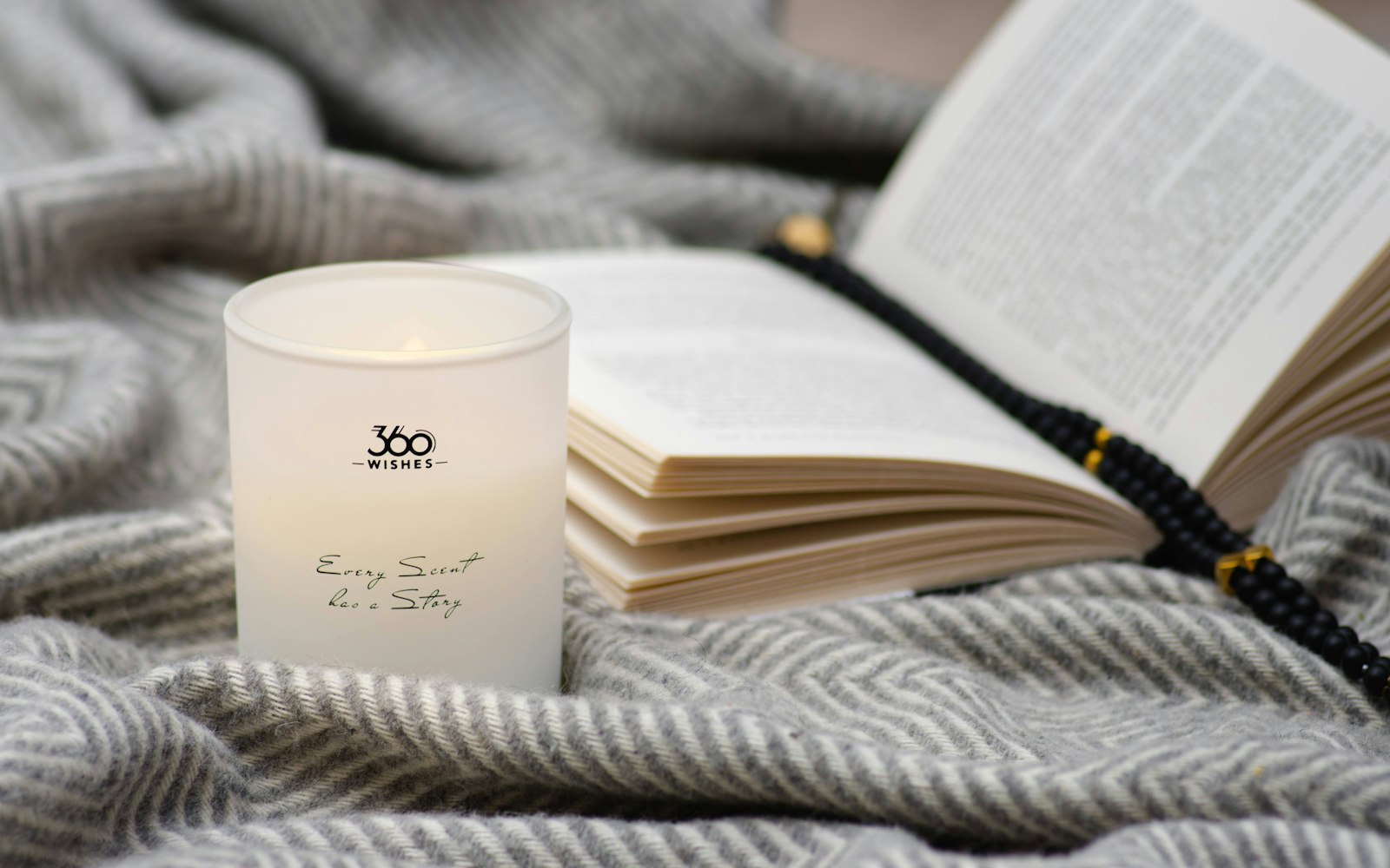 Candle and book on a cozy blanket