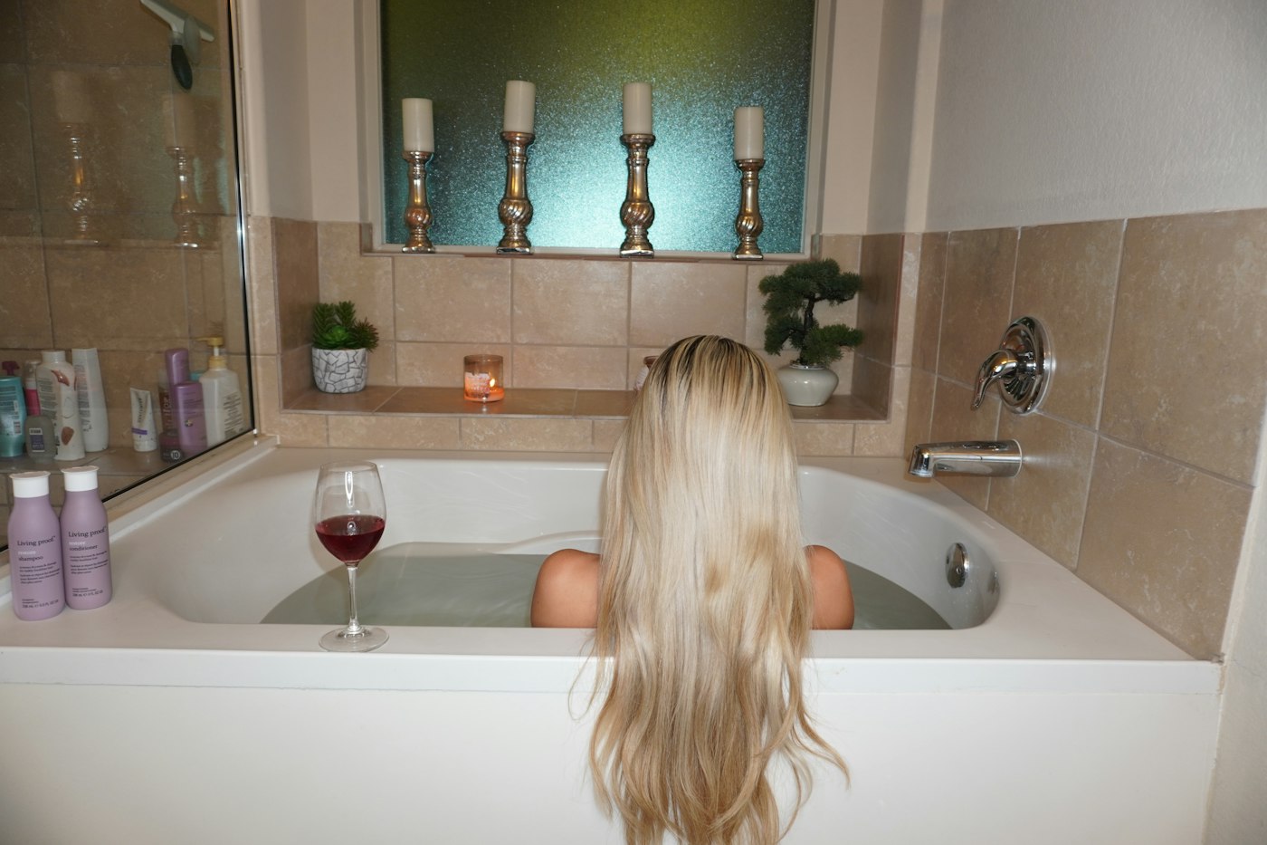 Woman relaxing in a bathtub with a glass of wine for Valentine's Day self-care